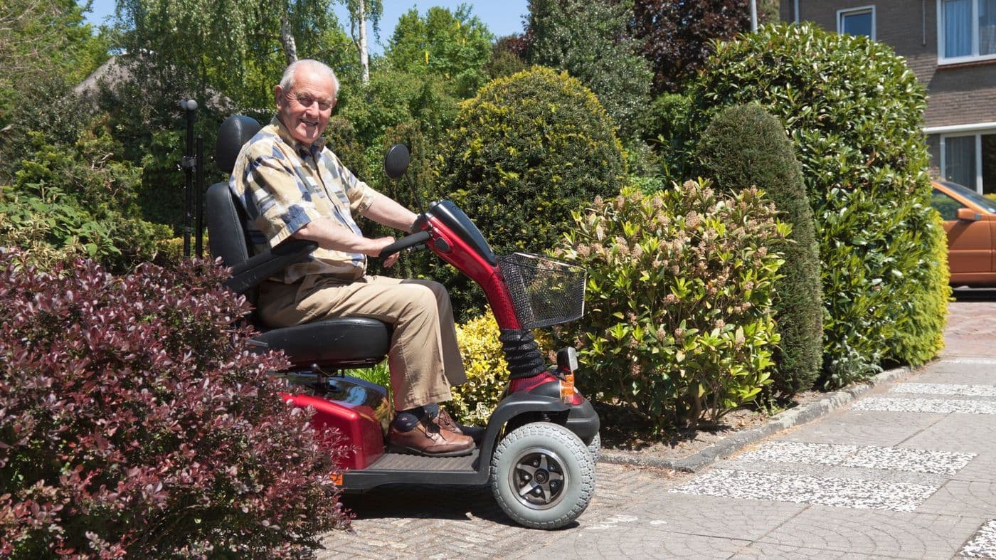 A mobility scooter parked on a driveway outside a house
